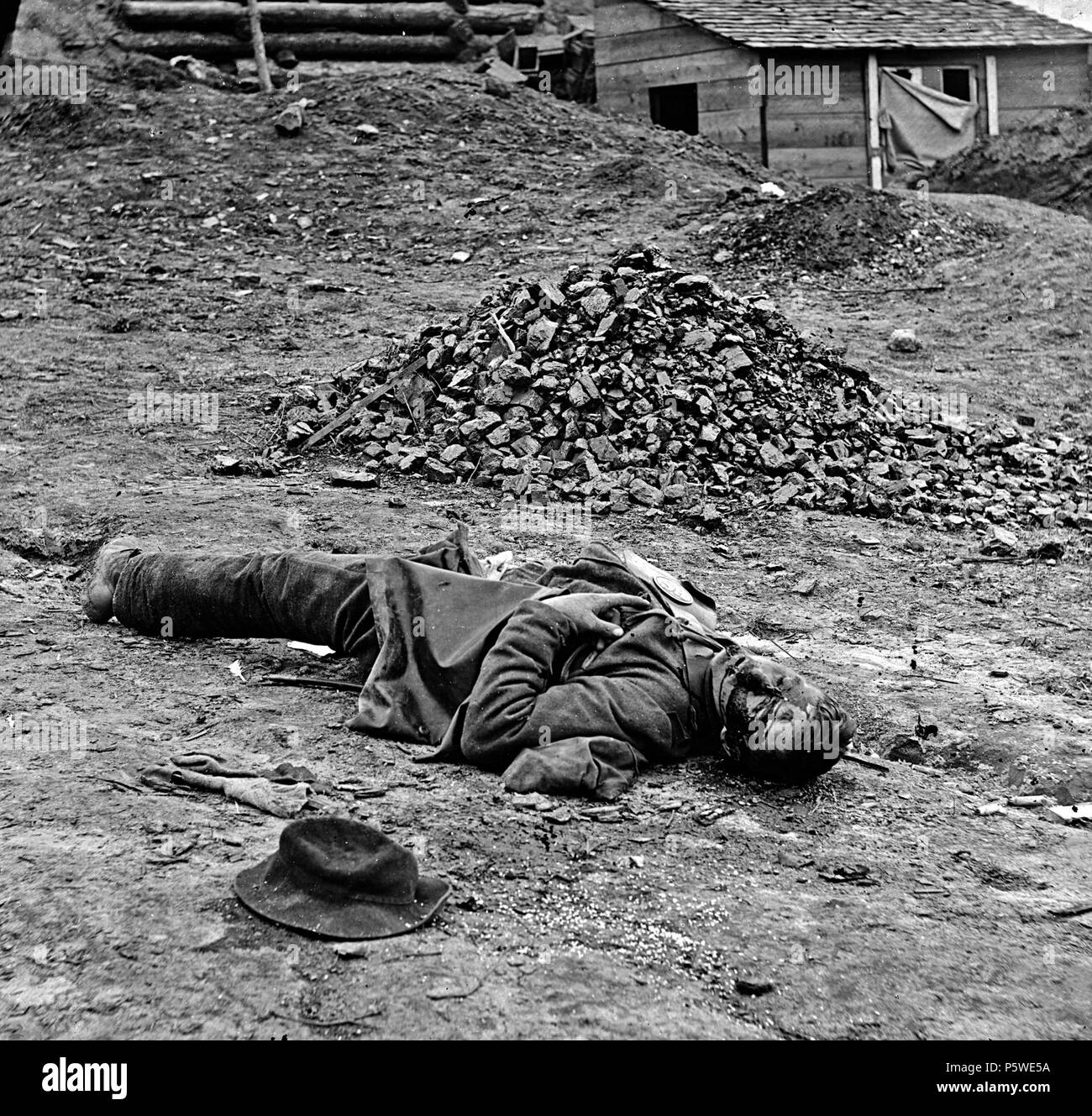 N/A. Petersburg, Virginia. Dead Confederate soldier in trenches before Petersburg. Photo shows, according to Thomas Roche's caption, 'a Rebel soldier killed in the Rebel trenches before Petersburgh [sic]. The spots and marks on his face are blood issuing from his mouth and nose. The wound is in the head, caused by a fragment of shell.' (Source: David Lowe and Philip Shiman, 'Substitute for a Corpse,' Civil War Times, Dec. 2010, p. 40) . 1 April 1865. Thomas C Roche 1826-1895 430 Dead soldier (American Civil War - Siege of Petersburg, April 1 1865) Stock Photo