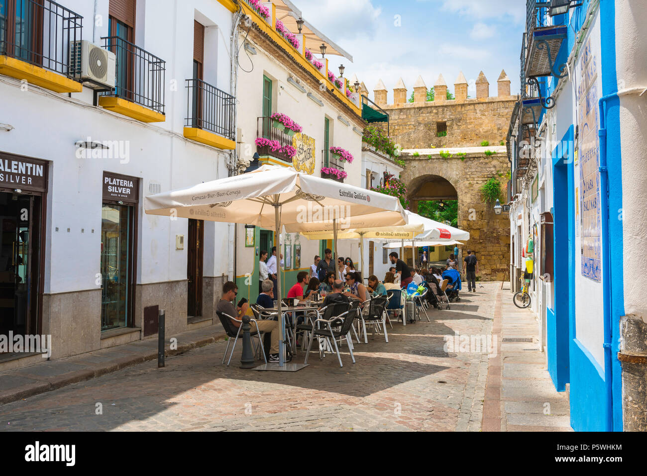 Cordoba Spain cafe, view of tourists relaxing on a cafe terrace in a street in the Juderia (old Jewish) quarter of Cordoba (Cordova) Andalucia, Spain. Stock Photo