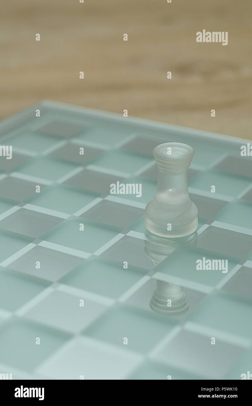 A rook chess piece made of glass displayed on a glass chess board Stock ...