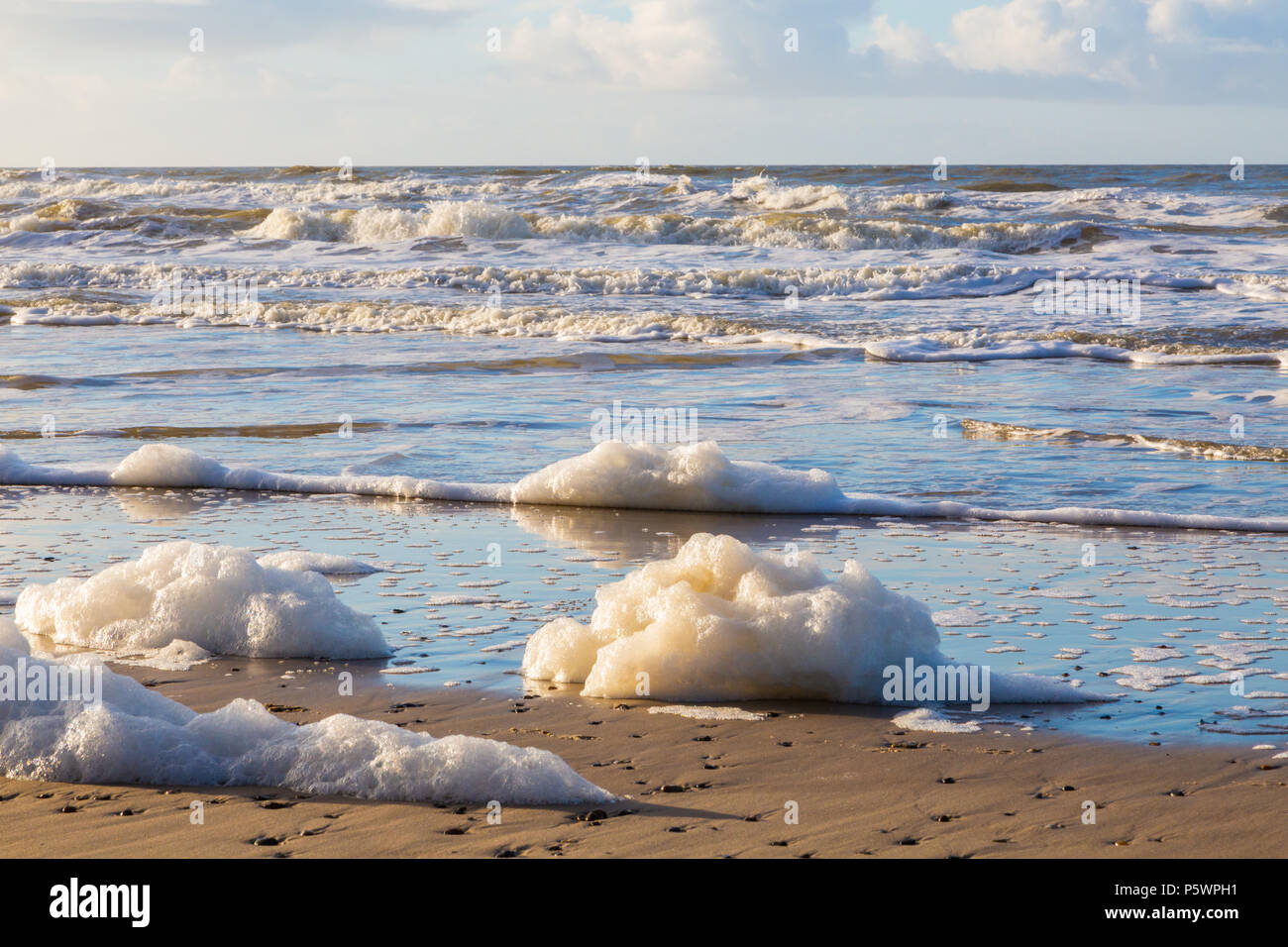 After storm in the North Sea. Sea foam on the beach in Hvide Sande, Denmark, after storm storm. Efter storm i Nordsøen. Havskum på stranden i Hvide Sa Stock Photo