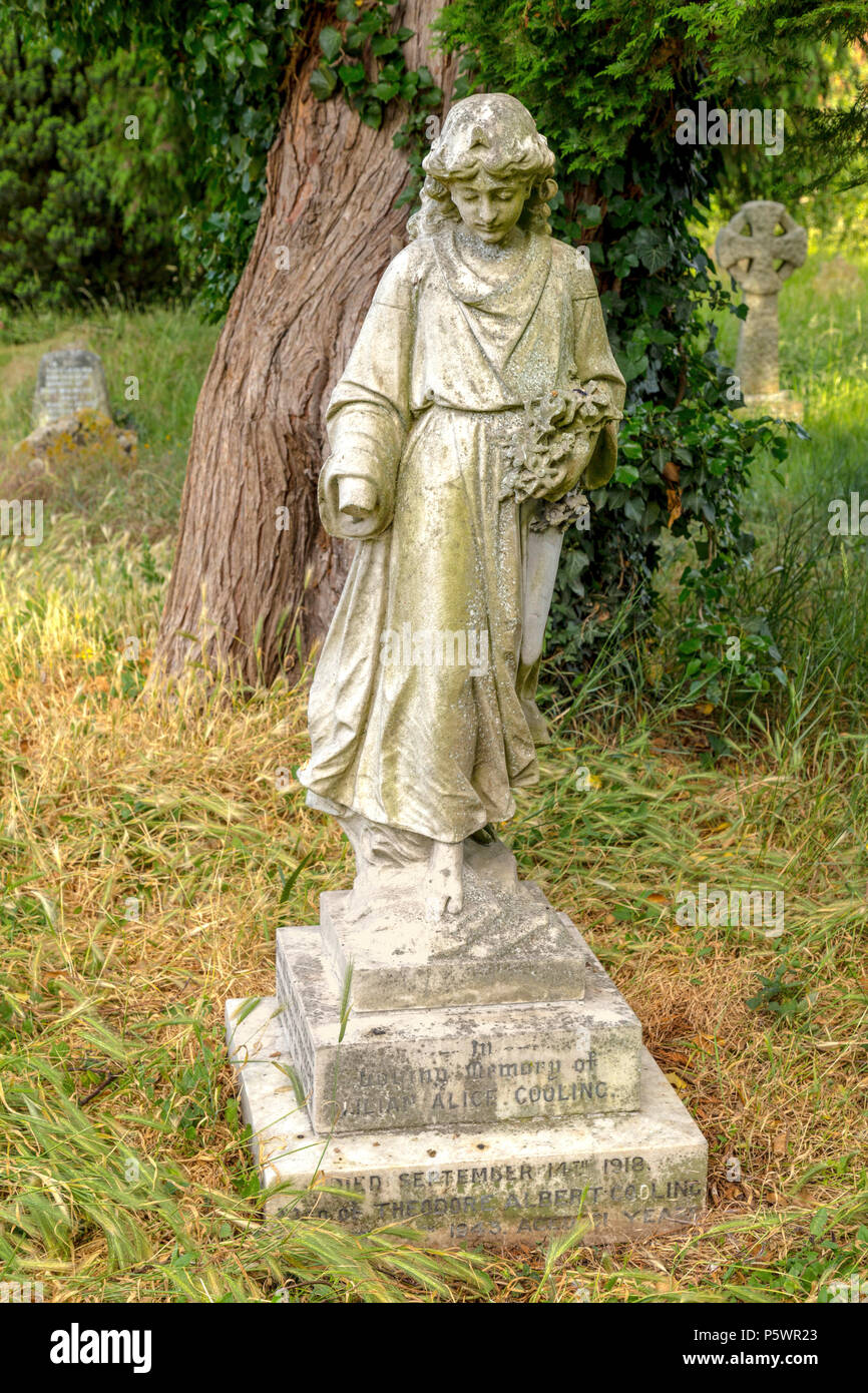 Statue of a robed female with floral wreath in the churchyard of St Thomas Church in Goring-on-Thames, Oxfordshire, England, United Kingdom. Stock Photo