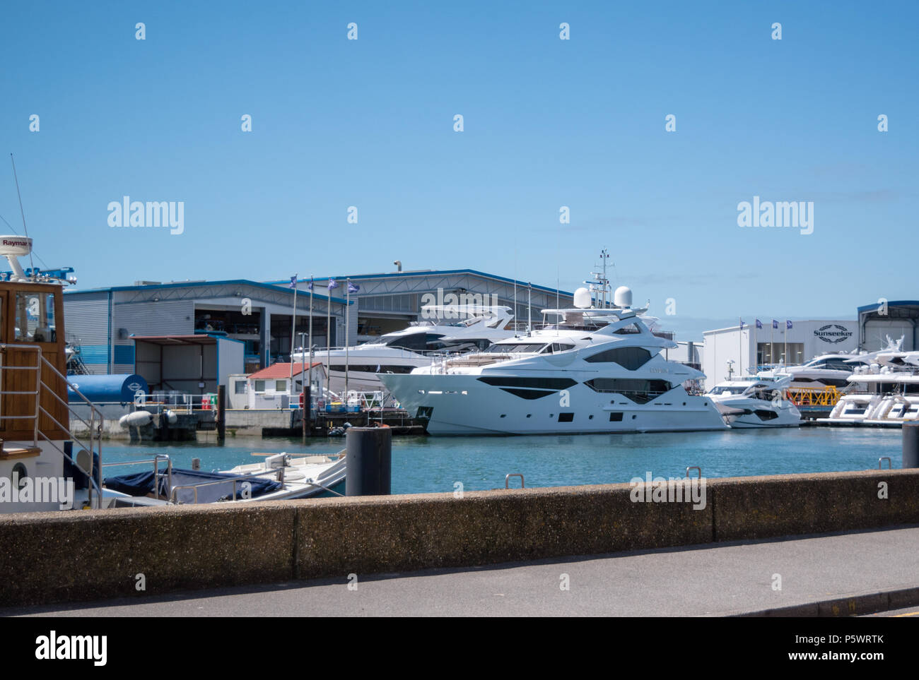 Sunseeker Luxury Super Yacht on a sunny day outside the manufacturers ship building headquarters in Poole Harbour, Dorset Stock Photo