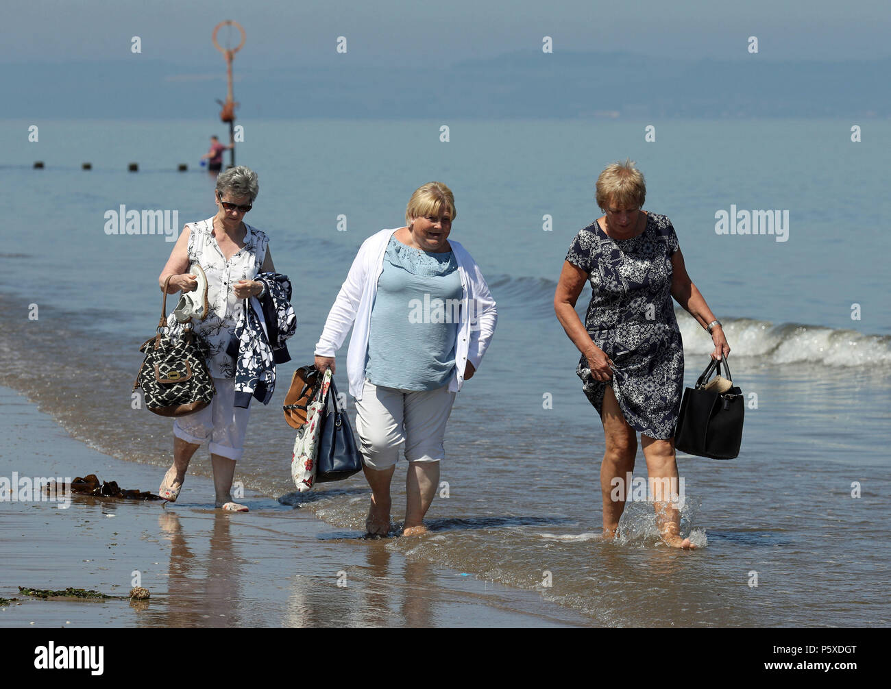 Women walk along the shore at Portobello beach, Edinburgh, as the hot