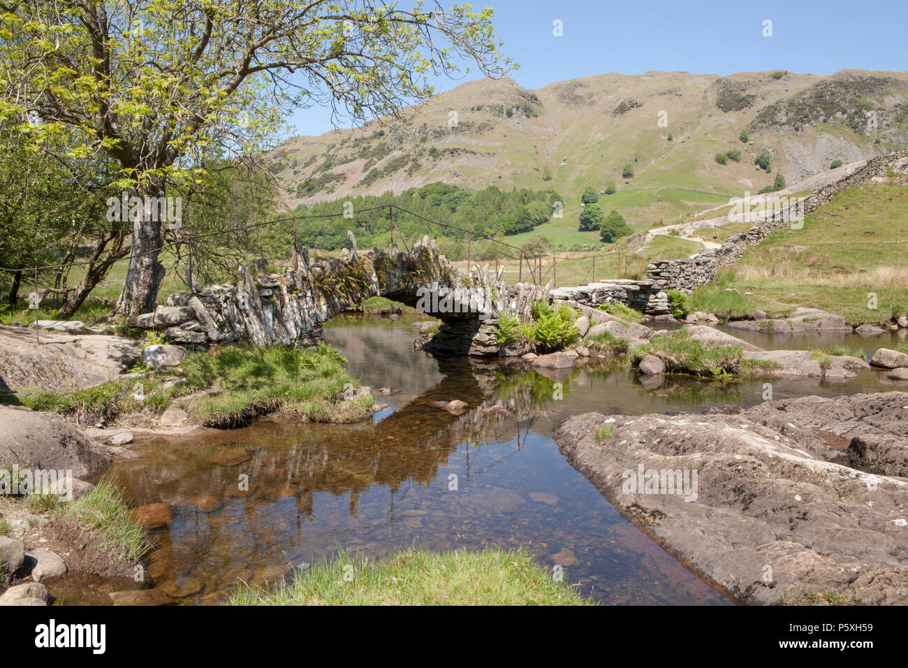 Slater's Bridge is a 17th Century pedestrian / packhorse slate bridge crossing the River Brathay in the English Lake District Stock Photo