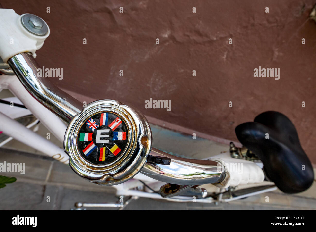 LJUBLJANA, SLOVENIA - JUNE 3, 2014: Metallic bicycle rusty bell with letter E for Europe and flags of eight European countries stands abandoned to rus Stock Photo
