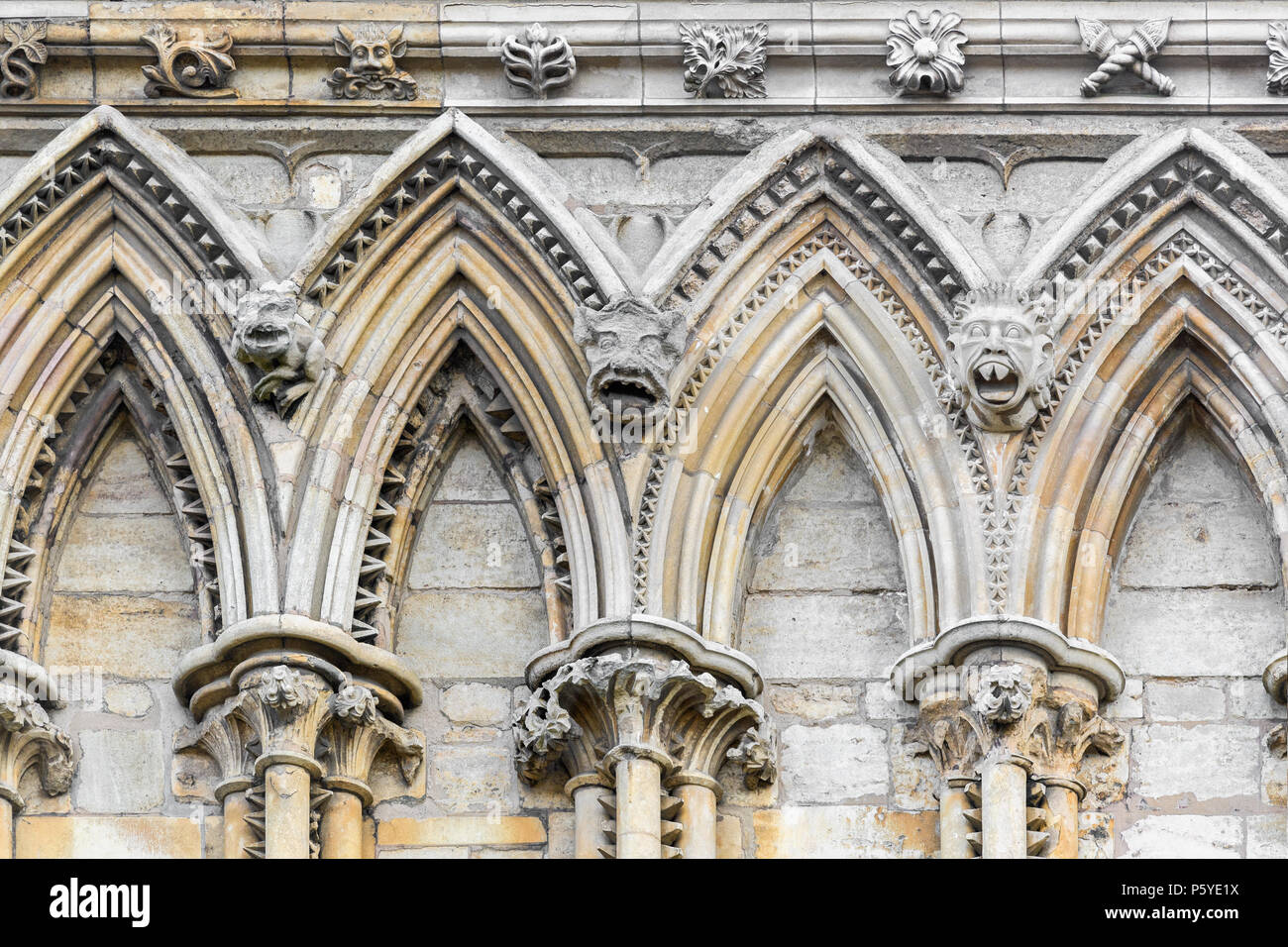 Decorated gothic stone arches on the west wall at the medieval cathedral, Lincoln, England Stock