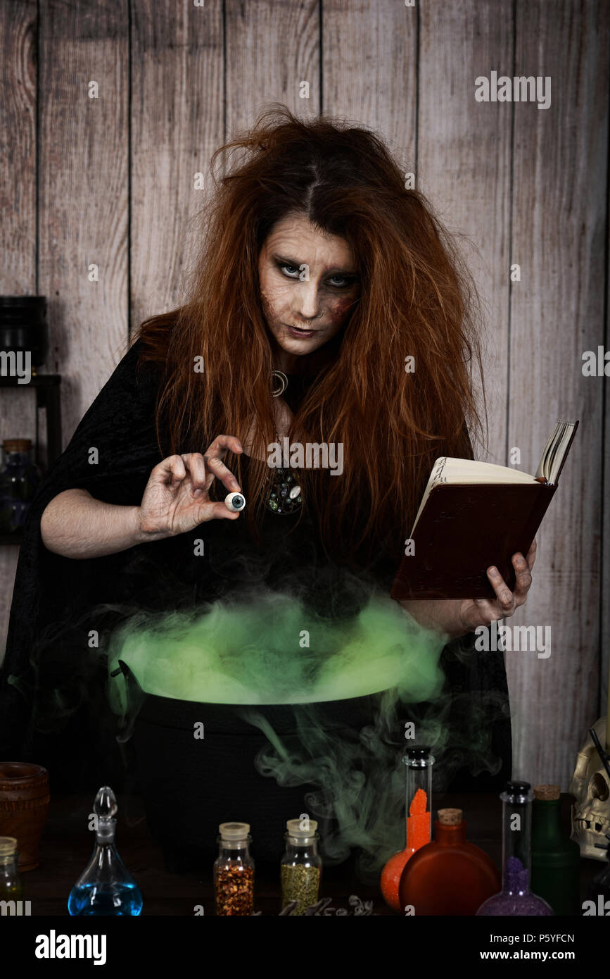 Witch Adding evil witch adding an eyeball to her magic potion Stock Photo - Alamy