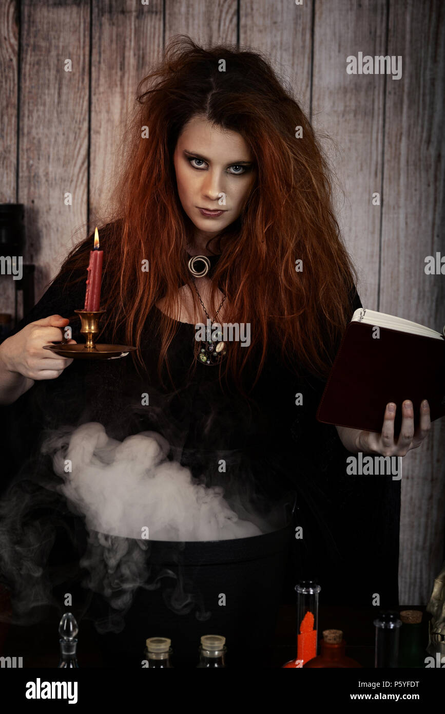 Witch Holding Spell Book And Candle Stock Photo 210202548 Alamy