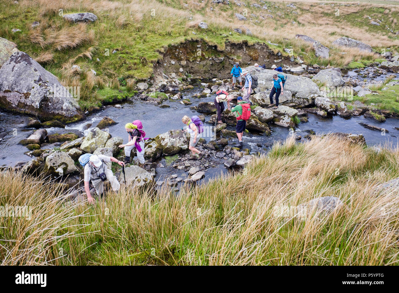 Group of hikers crossing Afon Llafar River in Carneddau mountains of Snowdonia National Park seen from above.  Bethesda, Gwynedd, Wales, UK, Britain Stock Photo