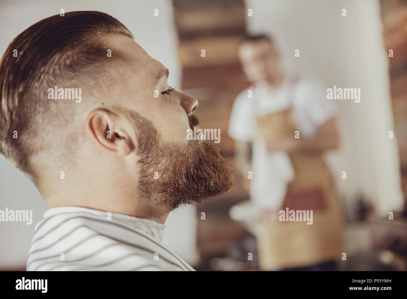Close-up of man's face with a beard while he is waiting for a barber. Photo in vintage style Stock Photo