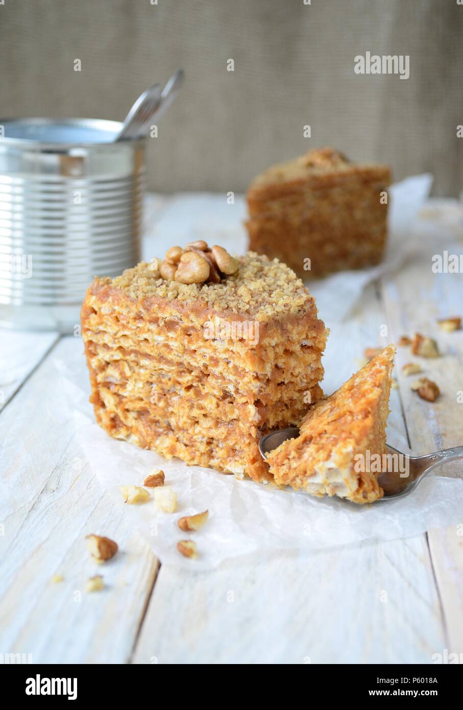 Waffle cake with condensed milk cream and walnuts on baking paper Stock