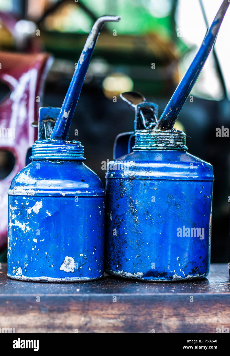 Old dirty metal blue oil cans sitting on the back of a steam tractor Stock Photo