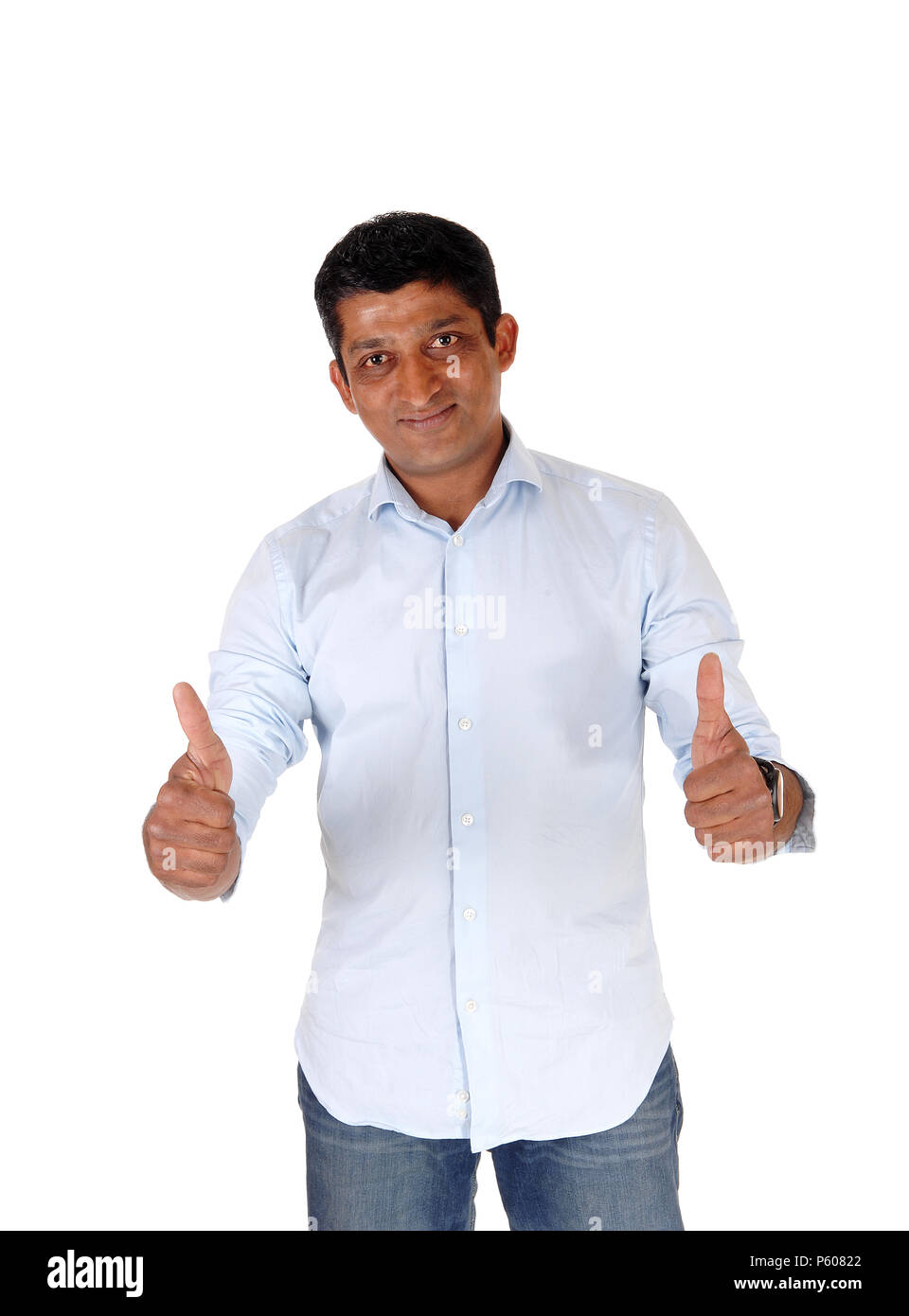 A closeup image on an East Indian man in jeans and blue shirt standing with booths of his thumps up, isolated for white background Stock Photo