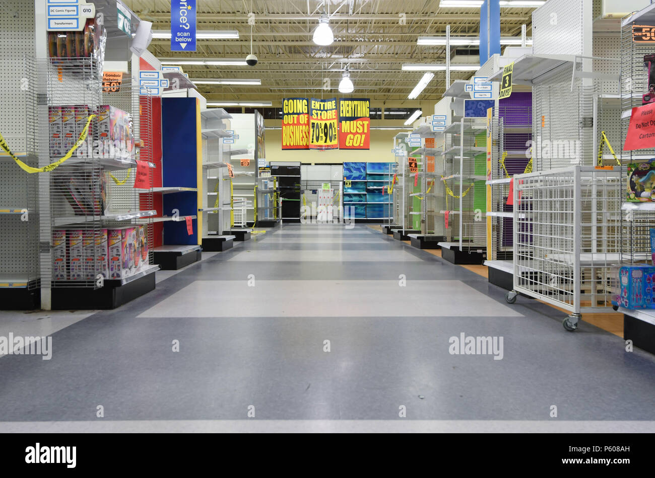 Clearance sale signs hang in an empty aisle in a Toys R Us store in Manchester, N.H., USA., June 25, 2018. Stock Photo