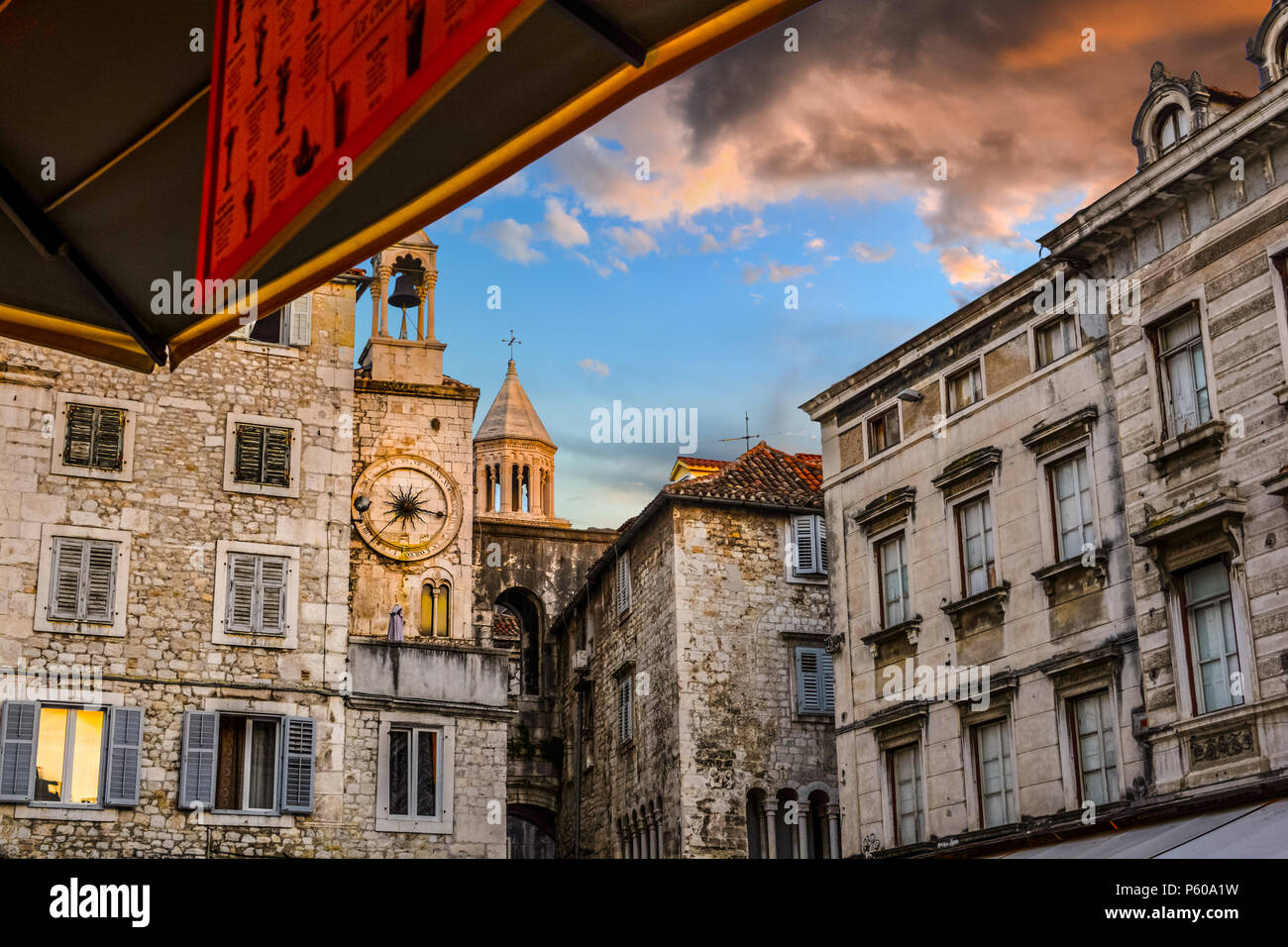 The bell and cathedral tower reflect the colorful clouds as the sun sets on People's Square at Diocletian's Palace in Split Croatia Stock Photo
