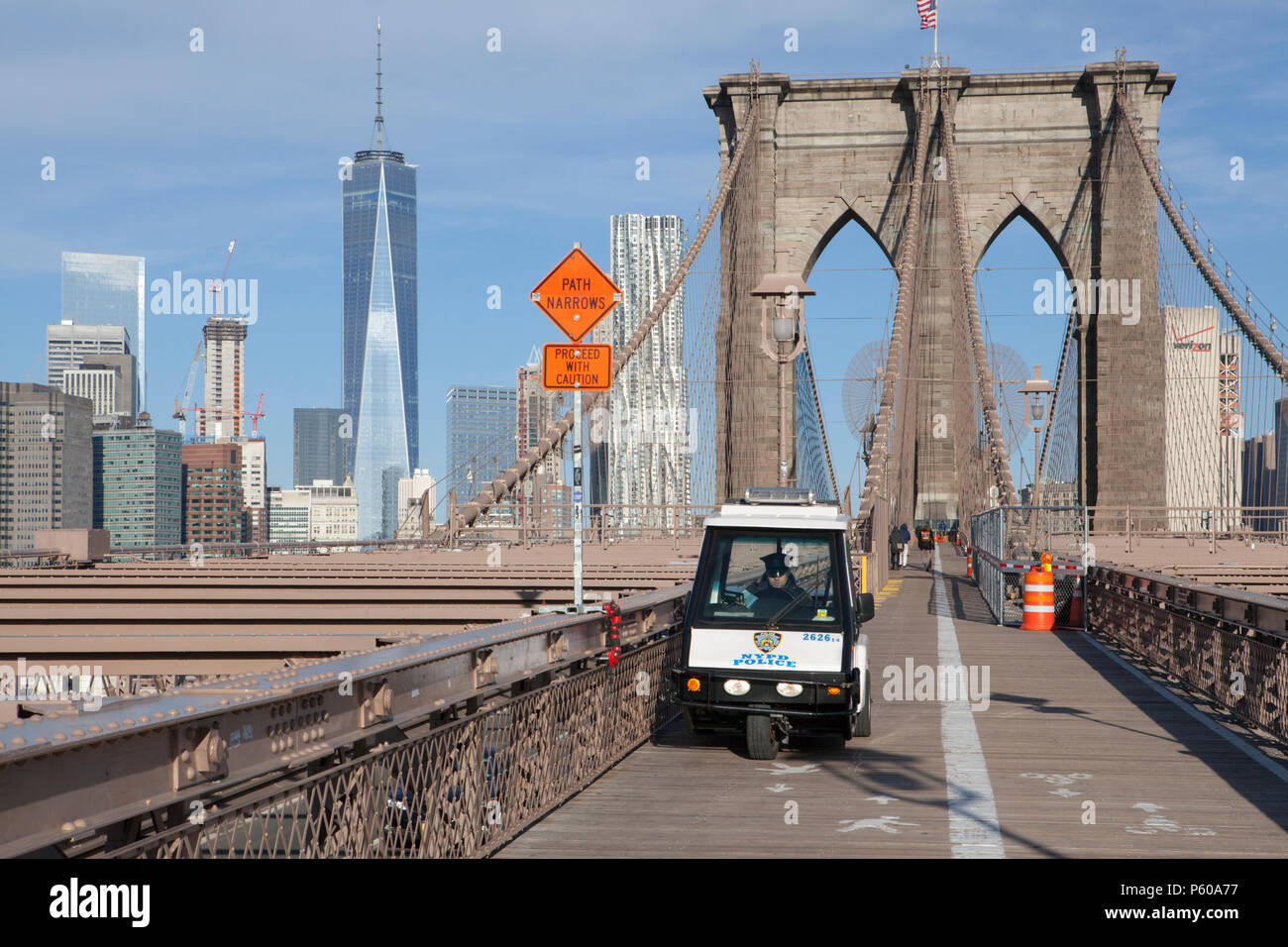 A NYPD cart sits on the Pedestrian Walkway of the Brooklyb Bridge with the Manhattan skyline in the background Stock Photo