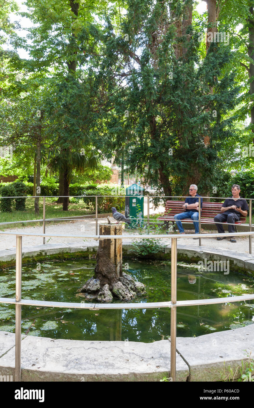 Papadopli Gardens, (Giardini Papadopoli) Santa Croce, Venice, Veneto, Italy, People relaxing at the pond in the shade of green trees Stock Photo - Alamy