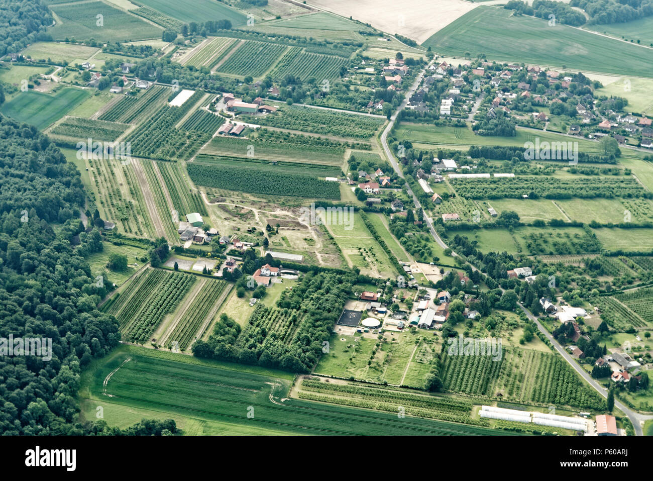 Urban sprawl in the north of Germany with small farmland, roads, houses, commercial enterprises and incoherent woodlands, aerial view Stock Photo