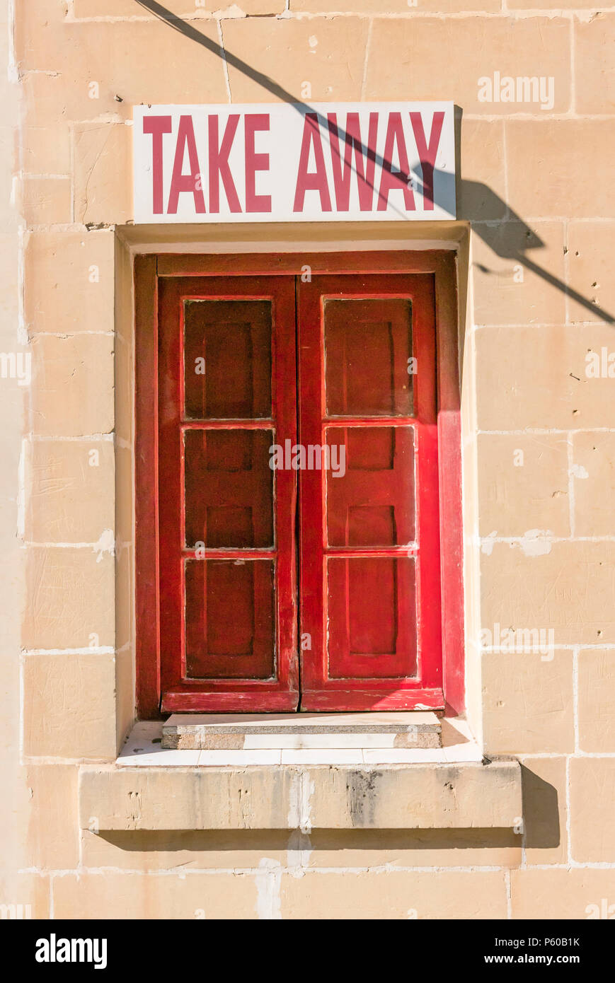 Red window and shutters with a sign above saying 'Take Away' Stock Photo