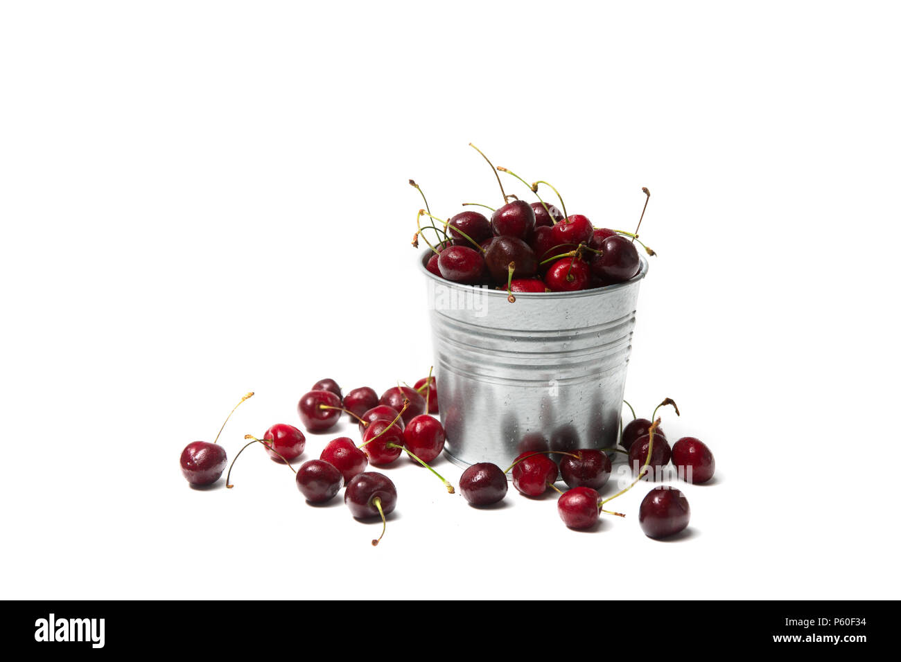 Little brass bucket of cherries isolated on white background Stock Photo