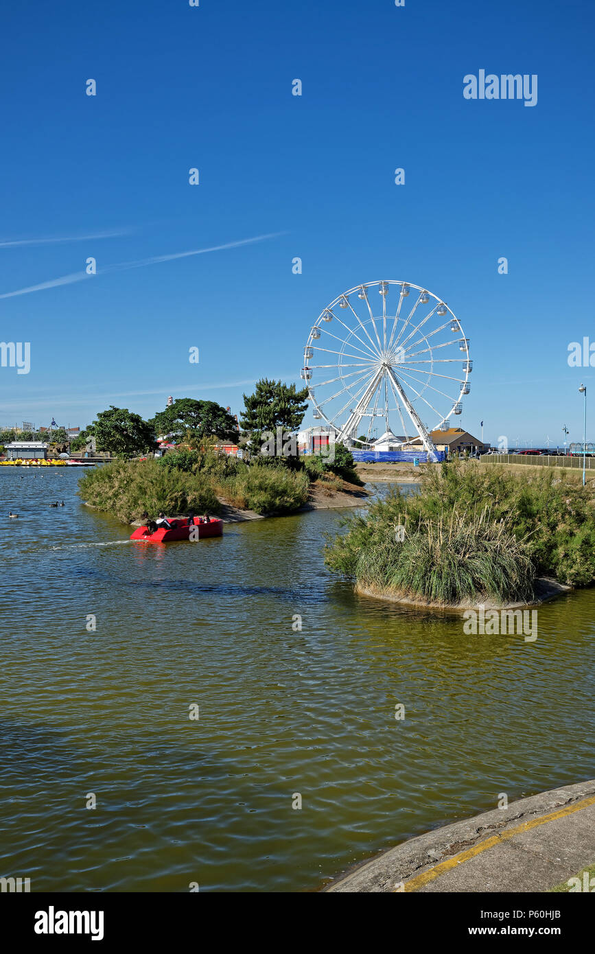 Boating lake and fairground wheel in the seaside town of Skegness, Lincolnshire,UK Stock Photo