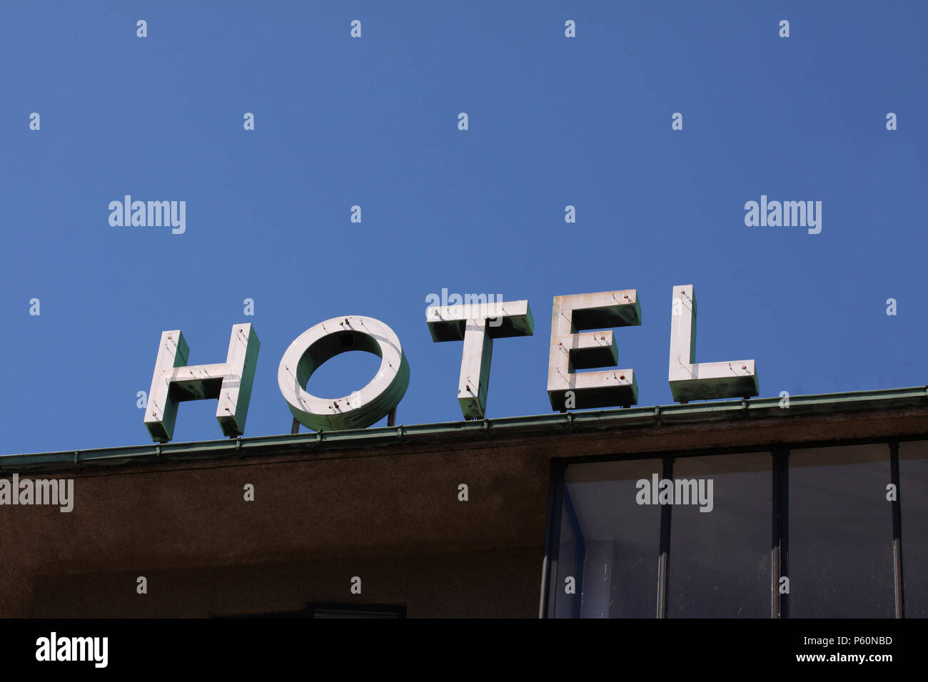 Anonymous hotel logo placed on a building against a clear blur sky with copy space for writing. Minimalistic modern stock photo. Stock Photo