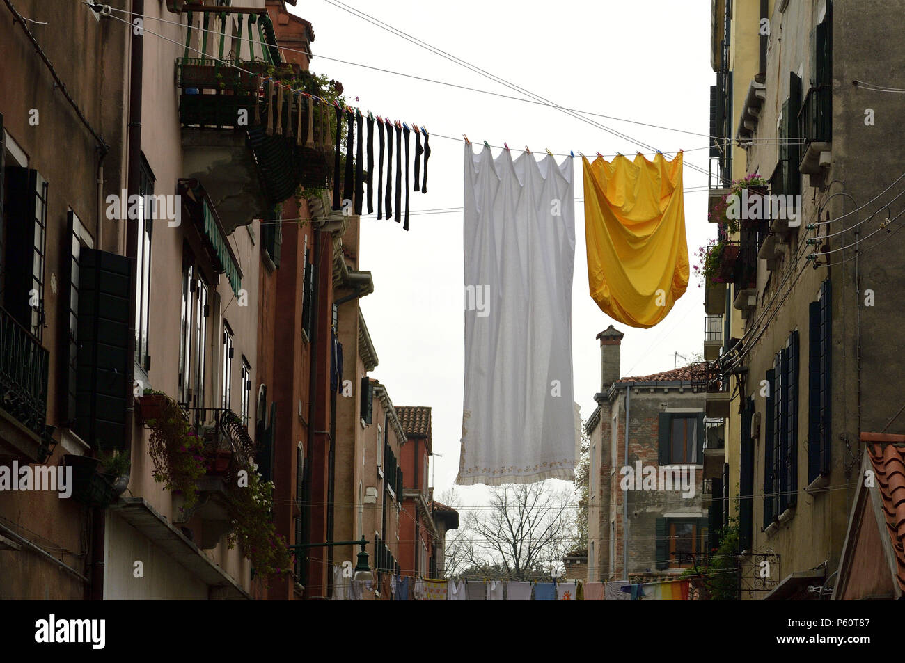 Clothesline on Ôlaundry dayÕ, between buildings in one of the off-beat residential neighboorhoods of the Commune di Venezia and Centro storico areas o Stock Photo