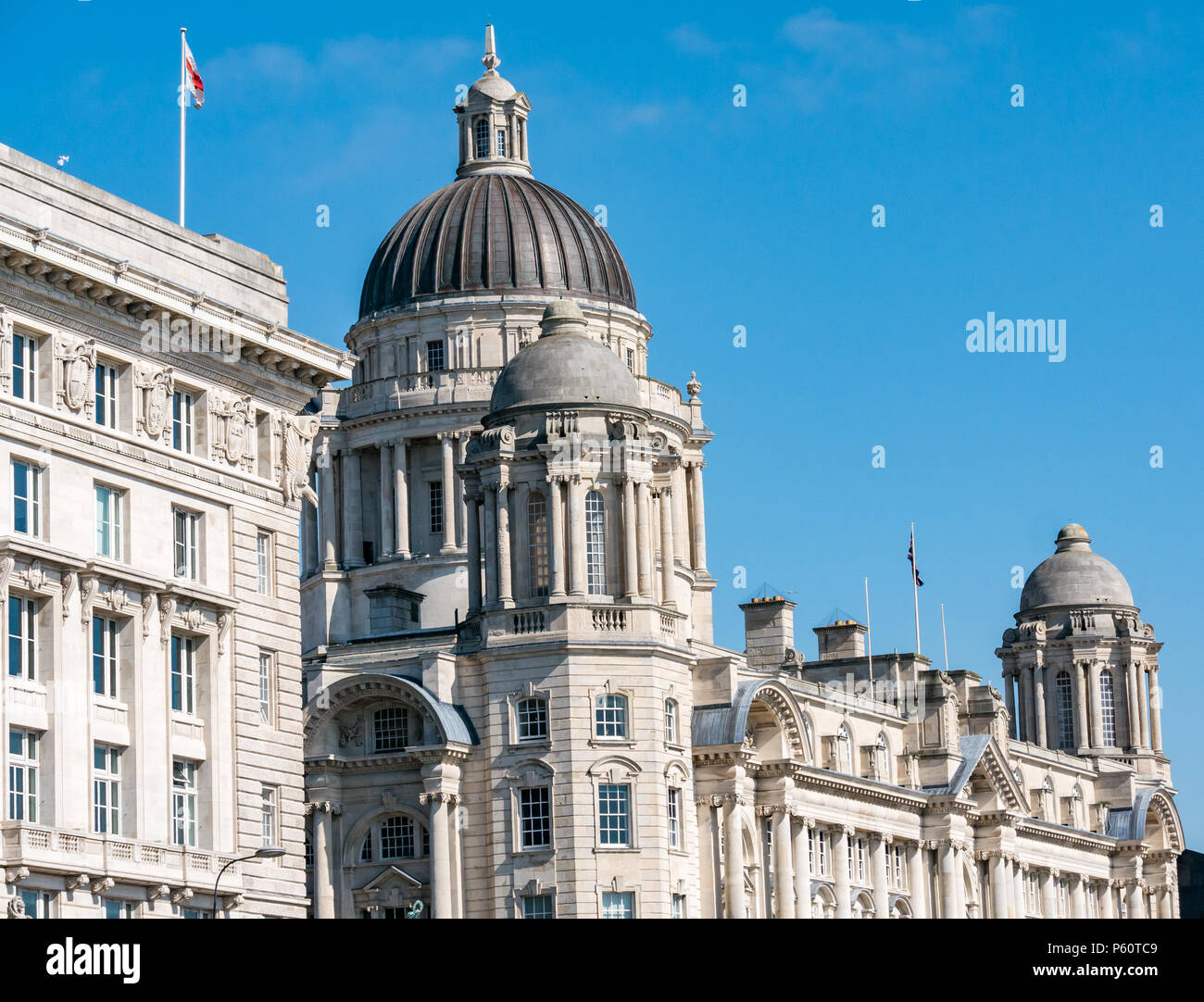 Three Graces, Cunard building and dome of  Edwardian Baroque Port of Liverpool building, Pier Head, Liverpool, England, UK with sunshine and blue sky Stock Photo