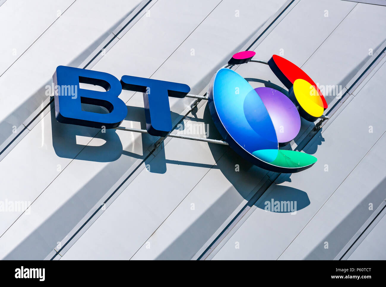 Close up view of BT name and colourful logo, Echo Arena Liverpool with blue sky, King's Dock, Liverpool, England, UK Stock Photo