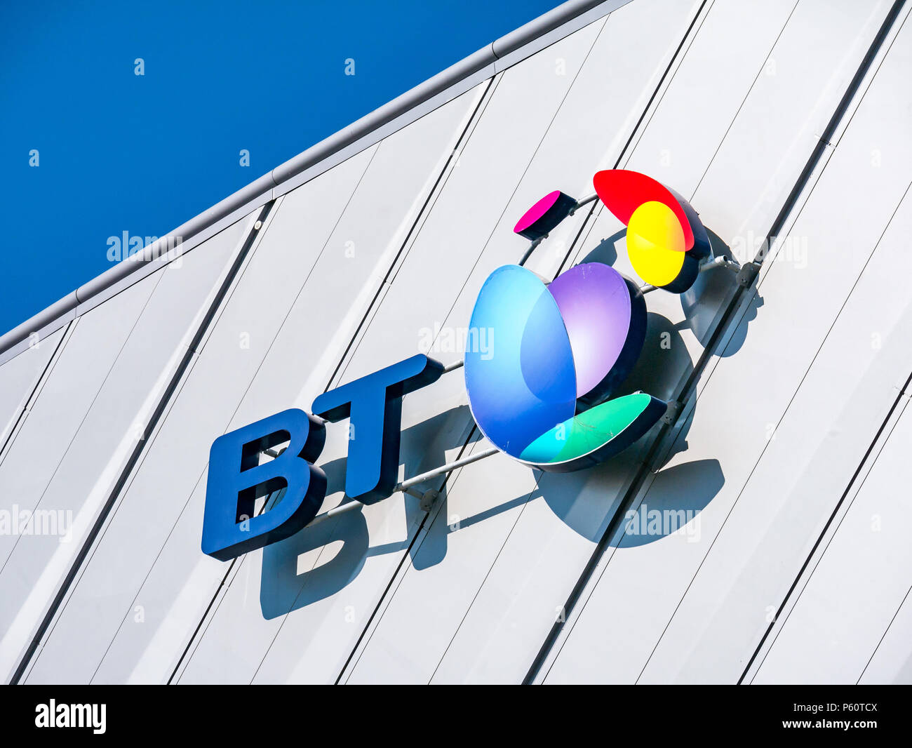 Close up view of BT name and colourful logo, Echo Arena Liverpool with blue sky, King's Dock, Liverpool, England, UK Stock Photo