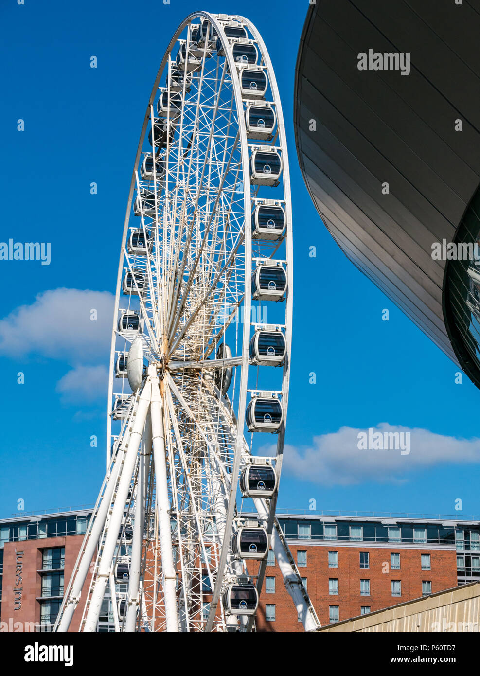 Wheel of Liverpool ferris wheel with Echo Arena, Kheel Wharf, Liverpool, England, UK with blue sky Stock Photo