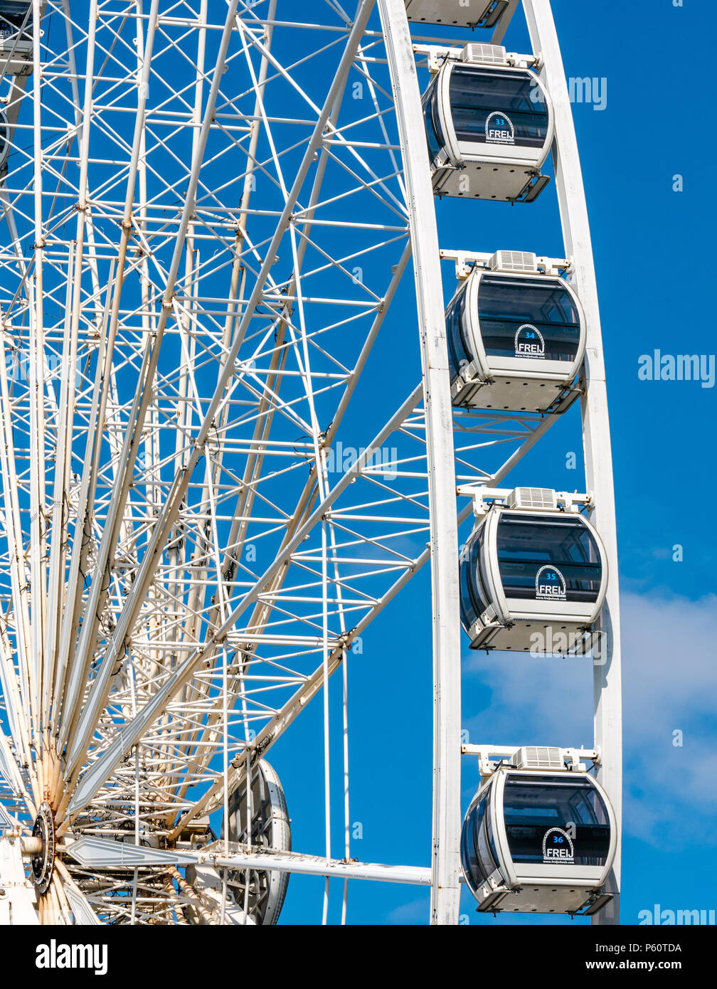 Wheel of Liverpool ferris wheel, Kheel Wharf, Liverpool, England, UK with blue sky creating stark contrast Stock Photo