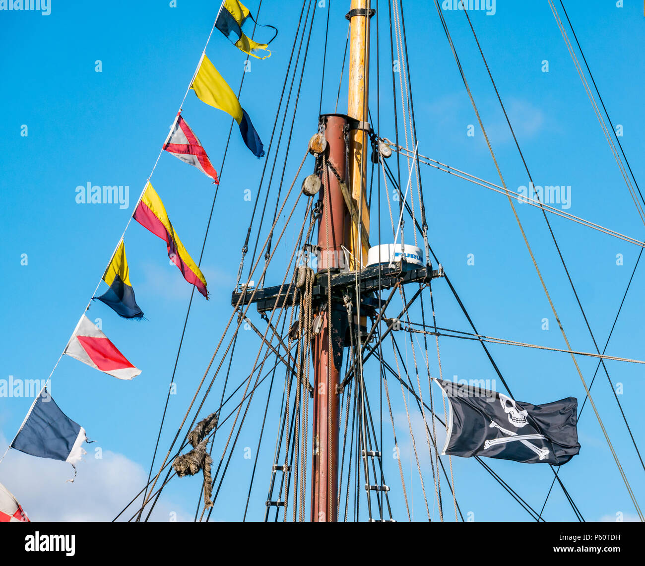Vview of mast of sailing ship with pirate flag, pennants and radar system, Albert Dock, Liverpool, England, UK Stock Photo