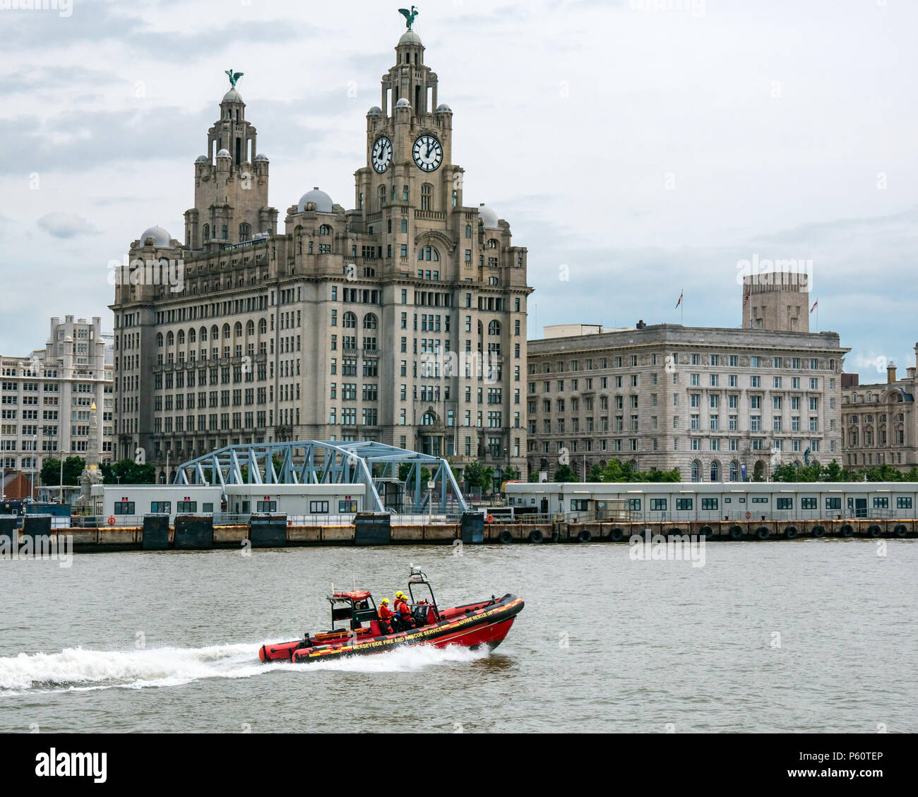 Merseyside Fire and Rescue rigid inflatable speed boat, River Mersey with city landmark Royal Liver building, Pier Head, Liverpool, England, UK Stock Photo