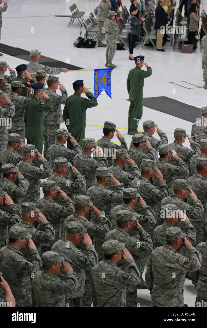 The assembled Airman of the 173rd Fighter Wing render a salute to the U.S. Flag during a change of command ceremony in which Col. Jeffrey S. Smith accepted the helm from Brig. Gen. Kirk S. Pierce who was promoted in an earlier ceremony. (U.S. Air National Guard photo by Tech. Sgt. Jefferson Thompson/released) Stock Photo