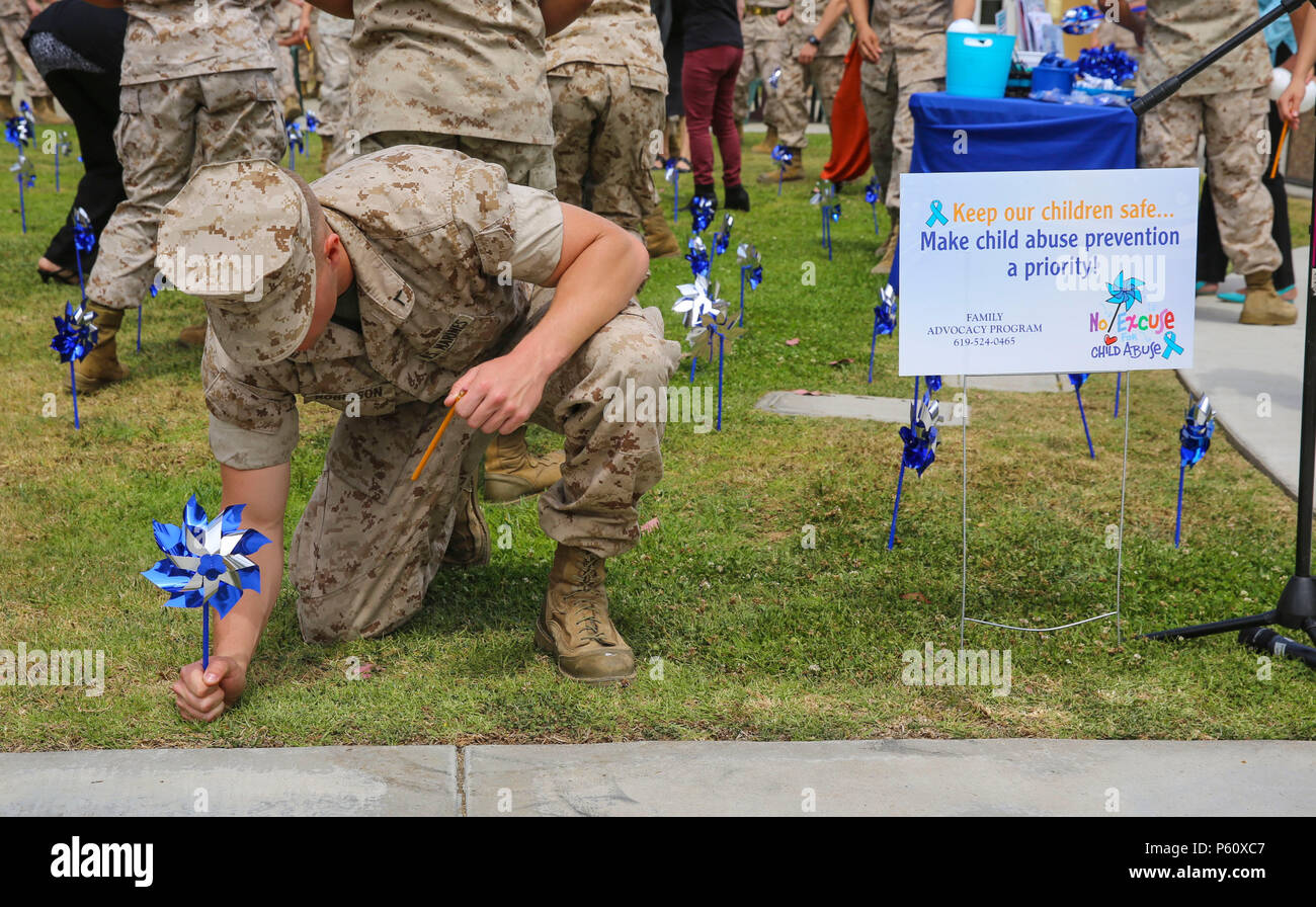 A Marine from Marine Corps Recruit Depot San Diego places a pinwheel in a garden area behind the Marine Corps Exchange during a Pinwheels for Prevention event here, April 5. This event brings recognition to supporting the healthy development of children nationwide. Stock Photo
