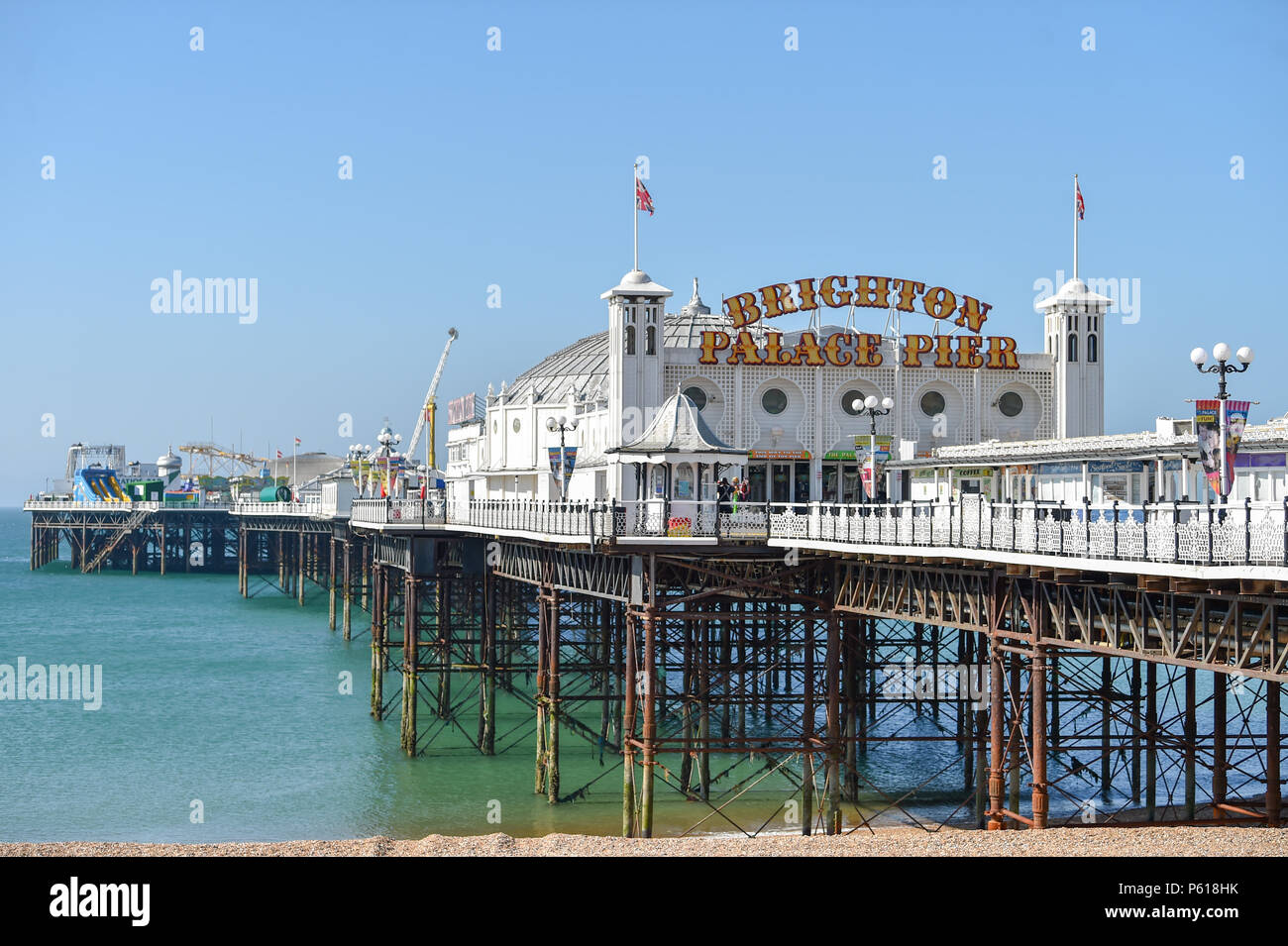 Brighton UK 28th June 2018 - Brighton Palace Pier showing off its new neon sign today after changing its name from Brighton Pier . The pier was built in the 1890s and named Brighton Marine Palace  and Pier but became known locally  as the Palace Pier until 2000 when it was rebranded Brighton Pier. Luke Johnson executive chairman of the Brighton Pier Group has now announced that it will be known as Brighton Palace Pier Credit: Simon Dack/Alamy Live News Stock Photo