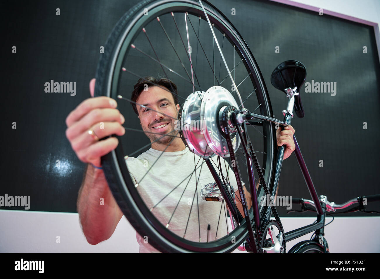 28 June 2018, Germany, Friedrichshafen: The model Thomas holds up a  Prototype Cooper E Disc during a press conference, a week before the start  of the bicycle fair 'Eurobike'. The bicycle has
