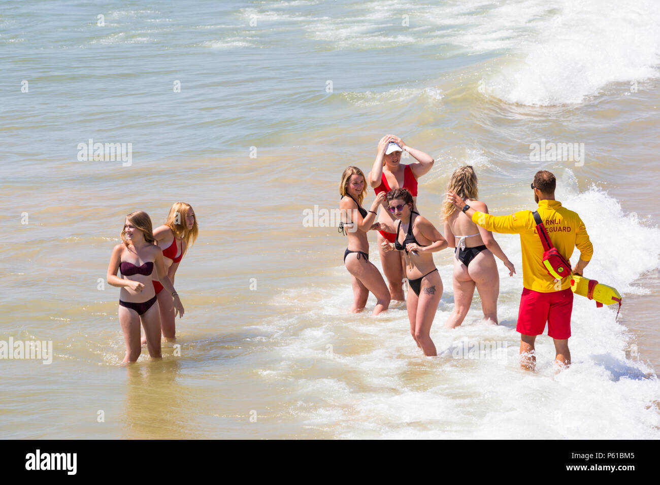 Bournemouth, Dorset, UK. 28th June 2018. UK weather: sunseekers head to the beaches at Bournemouth on another hot sunny day with unbroken blue skies and sunshine. A slight breeze makes the heat more bearable. A group of friends in skimpy bikinis have fun playing in the sea. Credit: Carolyn Jenkins/Alamy Live News Stock Photo