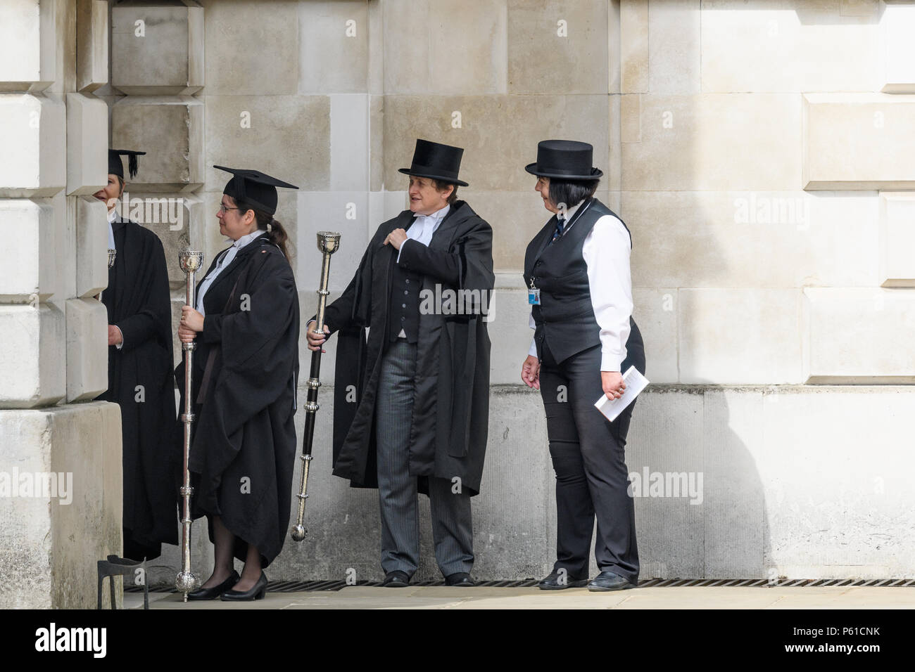 Cambridge, England. 28 June 2018. Esquire bedells with maces wait for the vice-chancellor, Stephen Toope, to process through the grounds of Senate House to the main building where he presides at the degree/graduation ceremony on 28th June 2018. Credit: Michael Foley/Alamy Live News Stock Photo