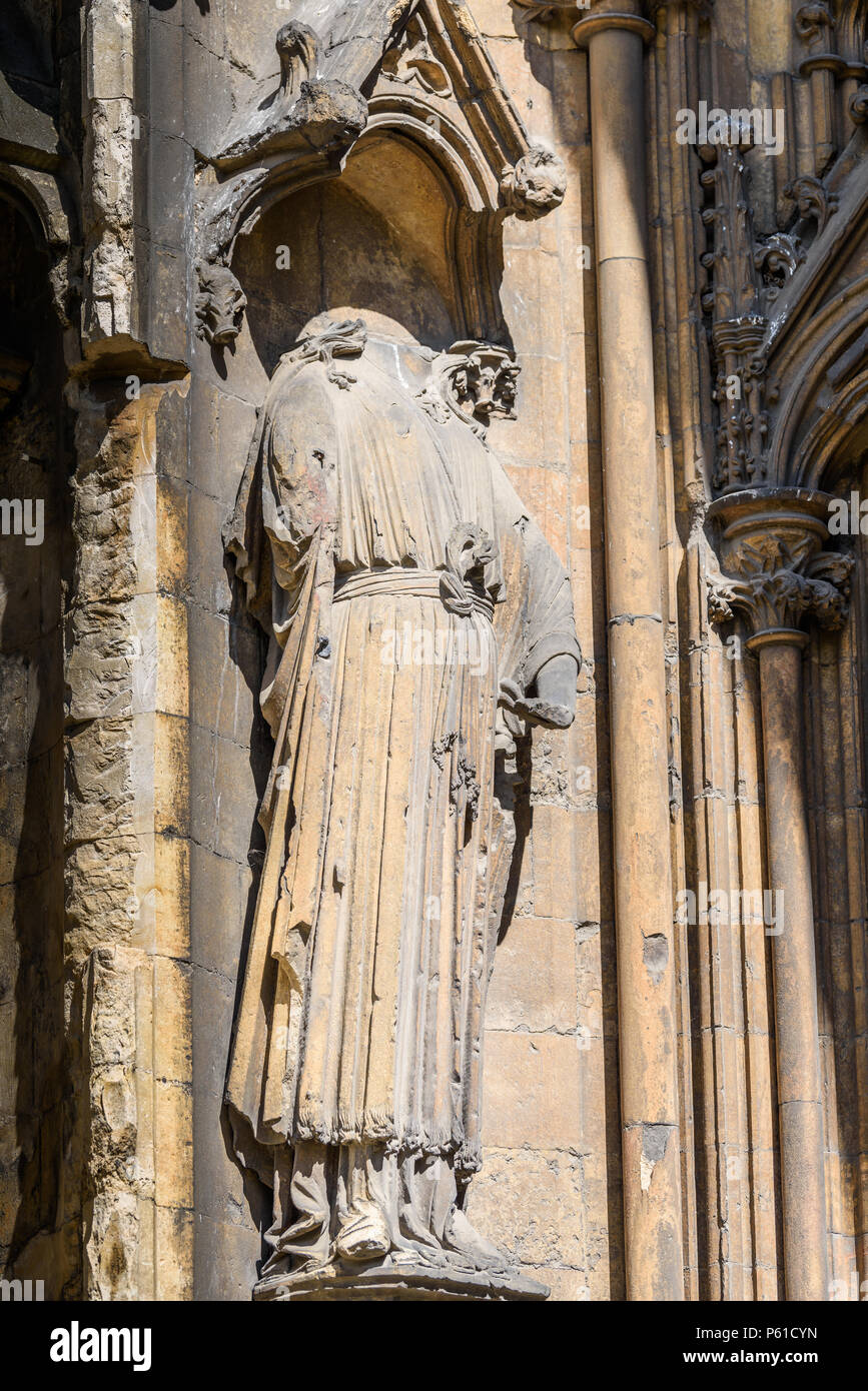 Vandalised statue in a niche on an outside wall at the medieval