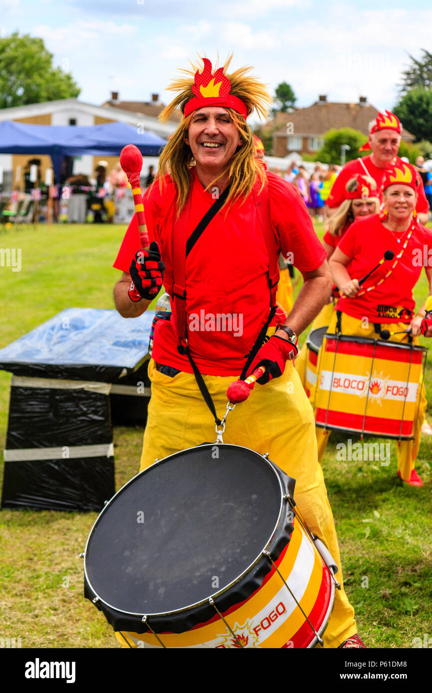 Characterful caucasian adult man, 30s, in the Bloco Fogo Samba Drumming Band, smiling while banging base drum at Coxhealth Custard Pie Championships. Stock Photo