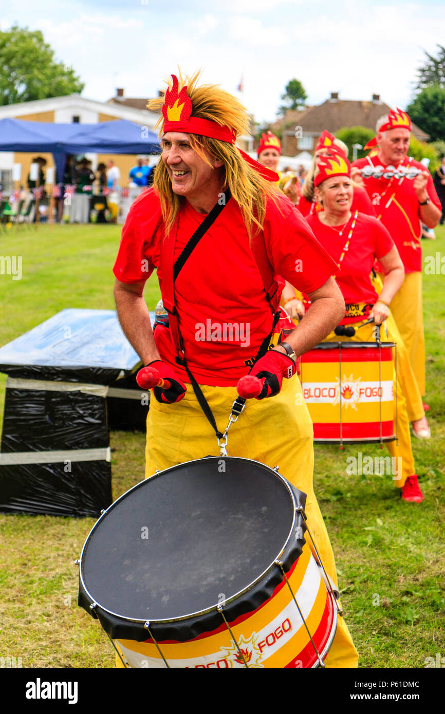 Characterful caucasian adult man, 30s, in the Bloco Fogo Samba Drumming Band, smiling while banging base drum at Coxhealth Custard Pie Championships. Stock Photo