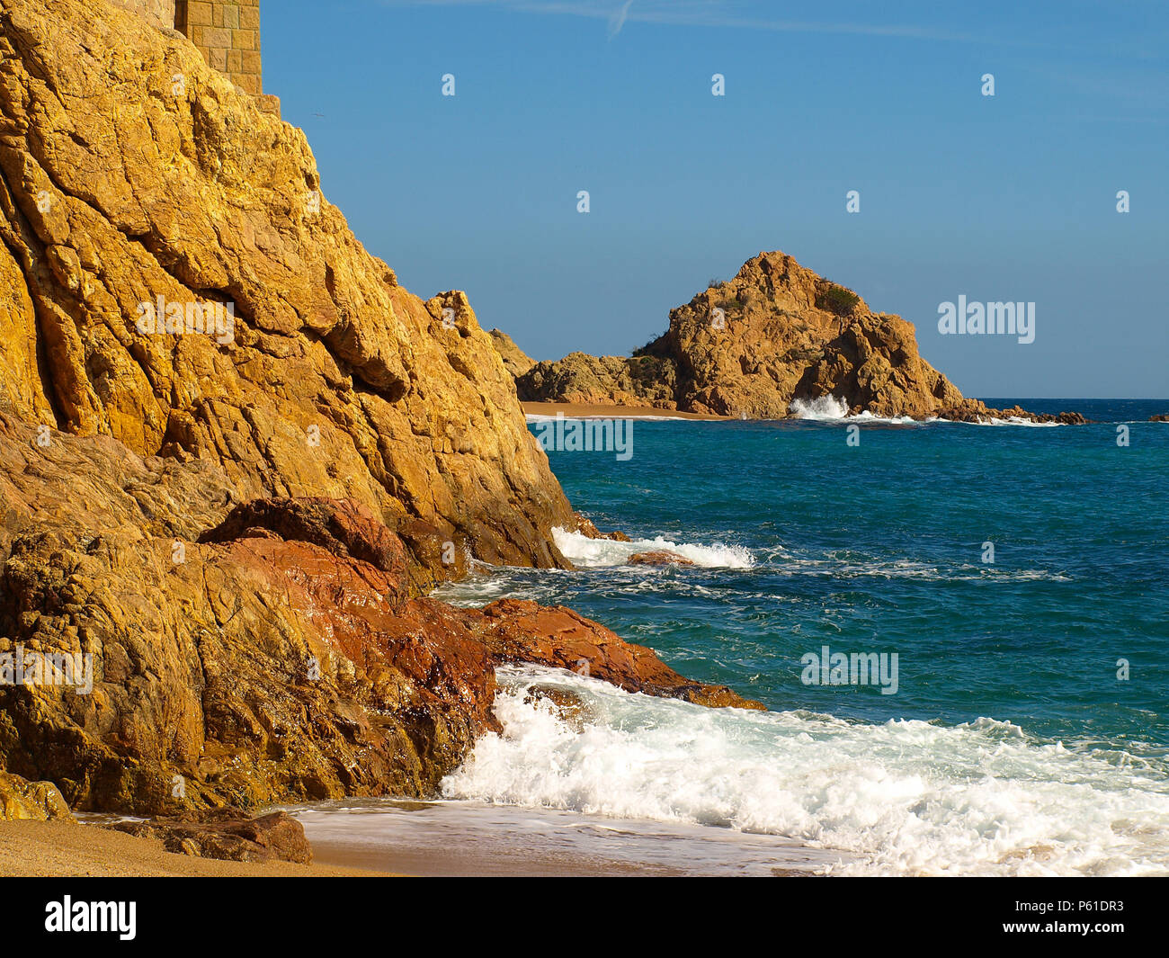 Seascape with the Mediterranean Sea and golden rocks on the beaches of Tossa de Mar, Spain Stock Photo