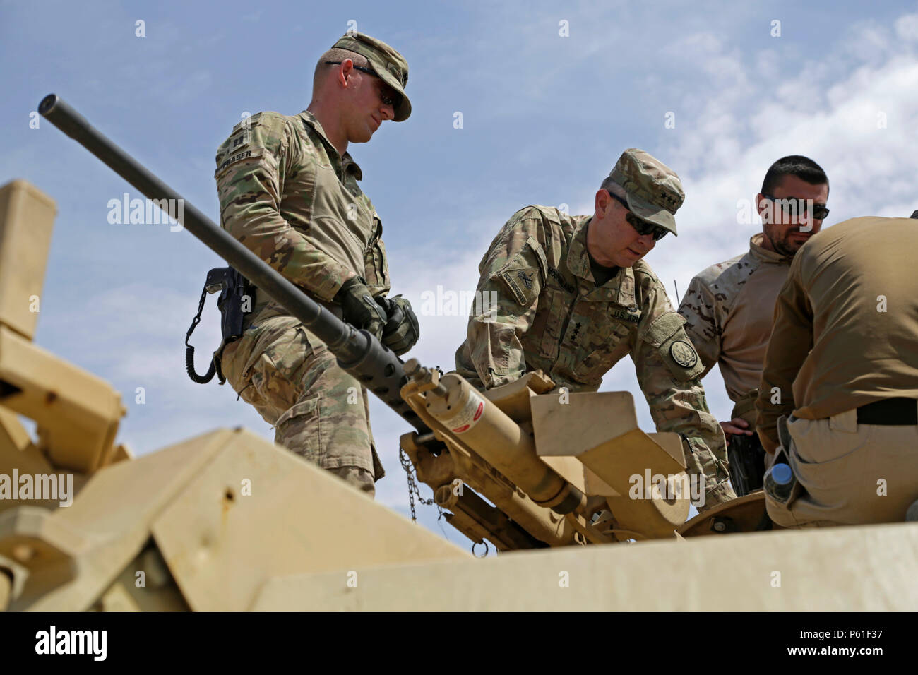 U.S. Army Lt. Gen. Sean MacFarland, center, commander of the Combined Joint Task Force - Operation Inherent Resolve, talks with U.S. Army trainers from 2nd Battalion, 70th Armored Regiment, 2nd Armored Brigade Combat Team, 1st Infantry Division, on top of an M1 Abrams tank during his visit to the Besmaya Range Complex, Iraq, April 6, 2016. MacFarland visited the Building Partner Capacity site to review current training, learn about future training capabilities and to discuss needs of the Iraqi Army. The Besmaya Range Complex is one of four CJTF-OIR BPC locations dedicated to training Iraqi Sec Stock Photo