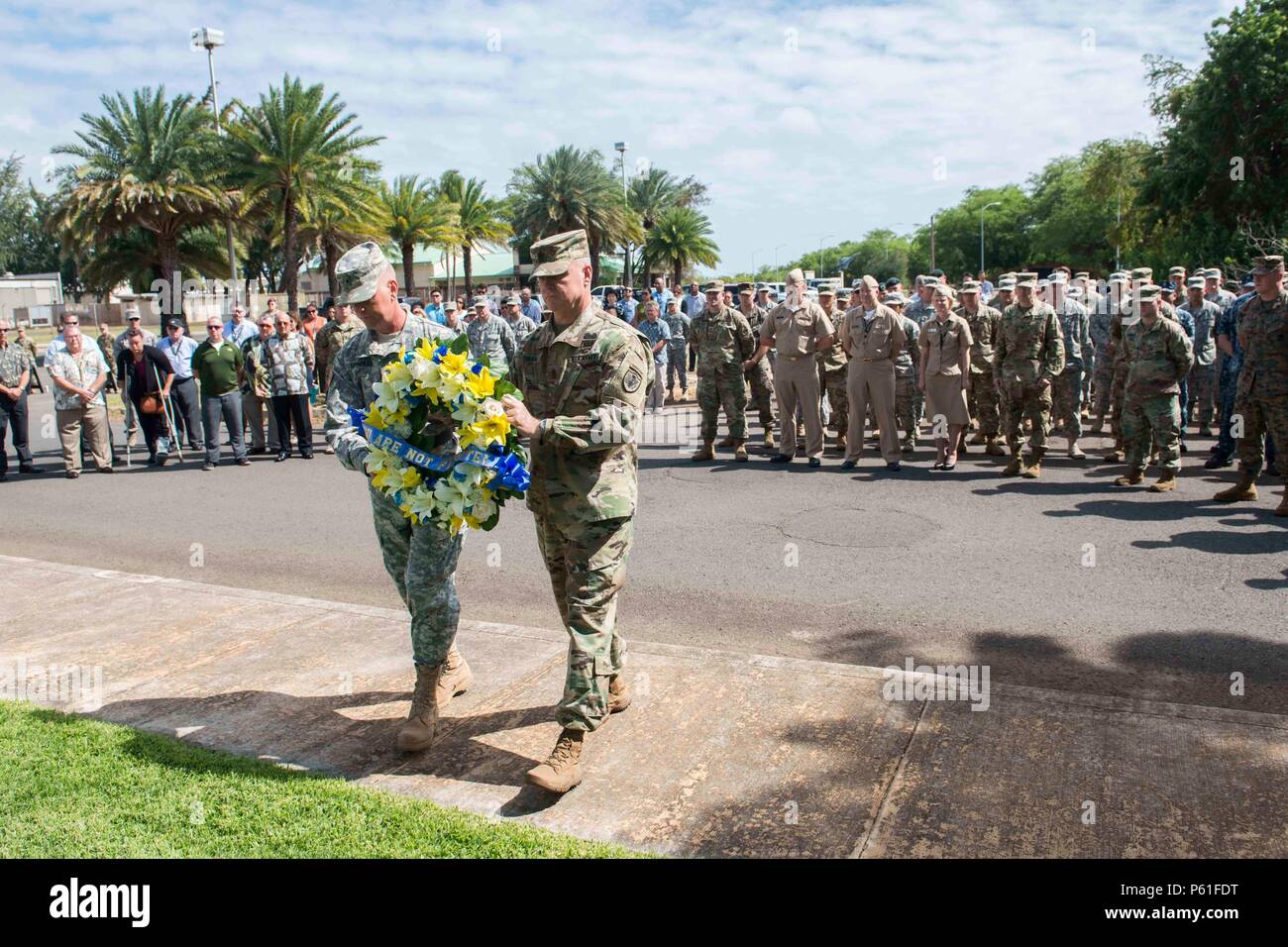 U.S. Army Brig. Gen. Mark Spindler, the Defense POW/MIA Accounting Agency deputy director, and U.S. Army Sgt. Maj. Michael Swam, DPAA senior enlisted advisor, carry a wreath as part of a memorial service held on Joint Base Pearl Harbor Hickam, April 7, to honor men killed in a helicopter crash, April 7, 2001 in Quang Binh, Vietnam. The 16 men were on an advanced party as part of a personnel recovery joint field activity. DPAA's mission to provide the fullest possible accounting of missing personnel to their families and the nation. (DoD photo by MC1 Vladimir Potapenko/Released) Stock Photo