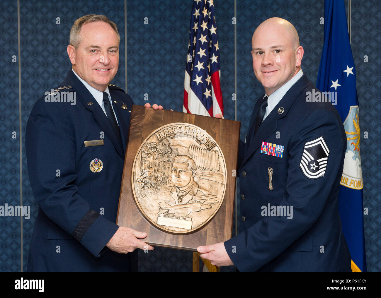 Air Force Chief of Staff Gen. Mark. A Welsh III presents the Lance P. Sijan Leadership award to Senior Master Sgt. Justin Deisch, a 2015 recipient, during a ceremony in the Pentagon, Washington. D.C., April 7, 2016. Deisch was a material flight chief assigned to the 705 munitions squadron, 5th maintenance group, 5th bomb wing, Minot Air Force Base, N.D., led 103 personnel across the only munitions squadron supporting the nuclear triad. The Sijan award, first presented in 1981, was named in honor of the first Air Force Academy graduate to receive the Congressional Medal of Honor. Each year it i Stock Photo