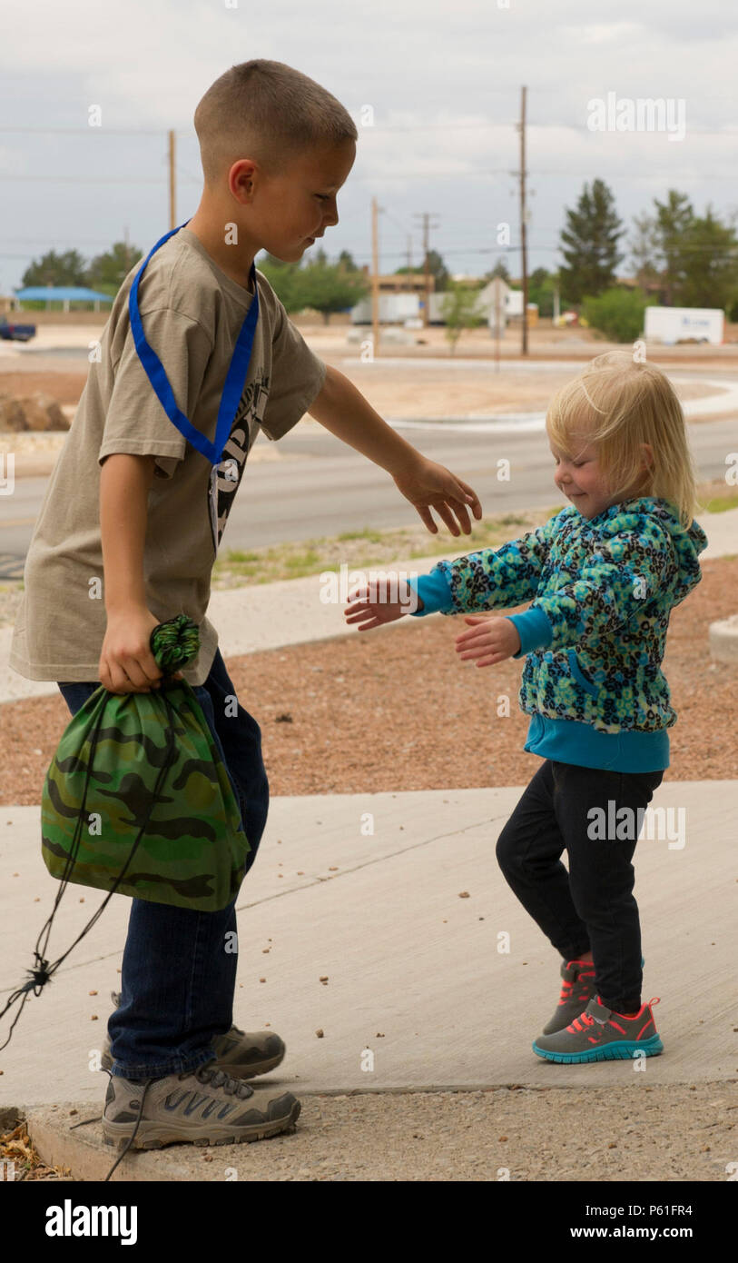 (HOLLOMAN AIR FORCE BASE, N.M.) Talib Berry, 9, is greeted by his younger sister Taeryn, 2, after returning from Operation K.I.D. (Kids Investigating Deployment), April 8 at Holloman Air Force Base, N.M.  This is Talib’s second year participating in Operation K.I.D. Each year, the Airmen and Family Readiness Center and the Youth Center host Operation K.I.D. in April, the Month of the Military Child. The A&FRC believes that it is important for children to experience what their parents go through during a deployment. (U.S. Air Force photo by Staff Sgt. E’Lysia A. Wray/Released) Stock Photo