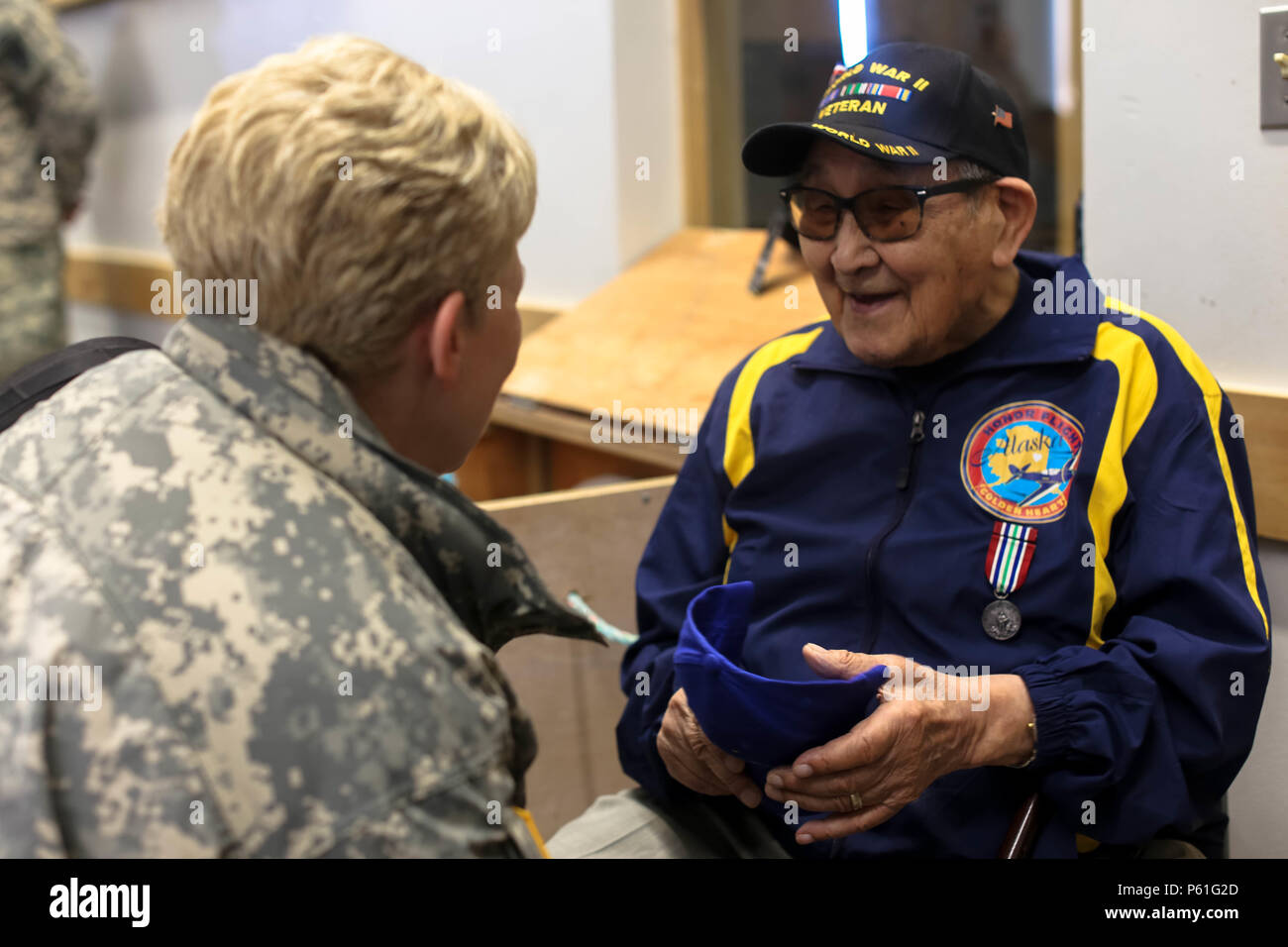 Brig. Gen. Laurie Hummel, commander of the Alaska National Guard, speaks with retired Alaska Army National Guardsman and WWII veteran, Wesley Atkin, during the cultural day event held at the Inupiat Heritage Center in Barrow, April 6, 2016. The cultural exchange marked the conclusion of a vigorous week of annual training by Guard members assigned to the Anchorage-based 297th Battlefield Surveillance Brigade, Alaska Army National Guard. (U.S. Army National Guard photo by Sgt. Marisa Lindsay) Stock Photo