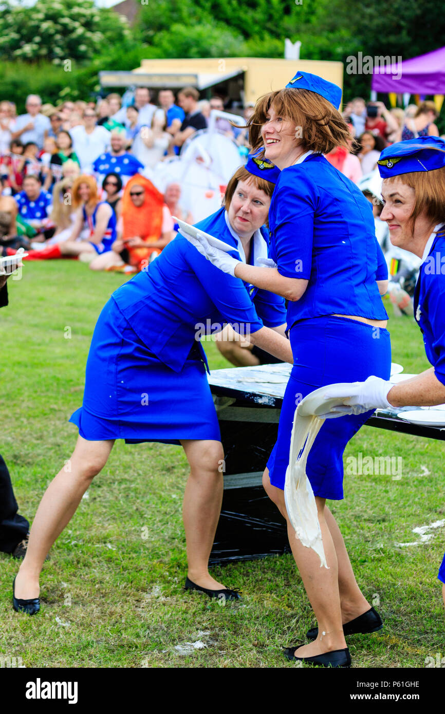 Three women dressed as stewardesses throwing custard pies during the